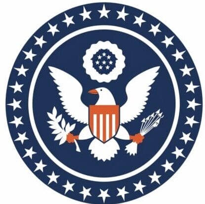 A blue circle with white stars and a white eagle with a red and blue shield.